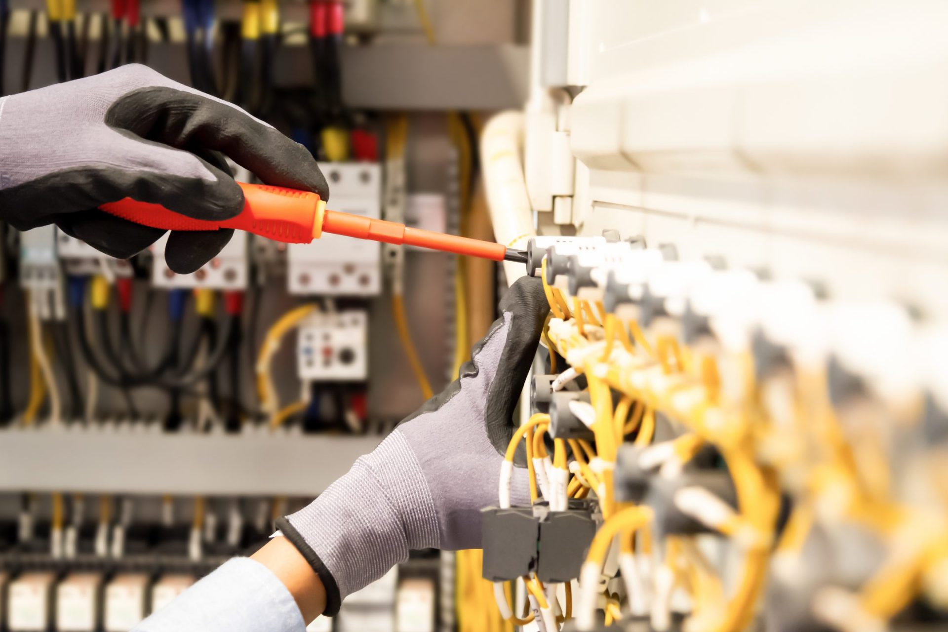 Electricians work to connect electric wires in the system, switchboard, electrical system in Control cabinet.